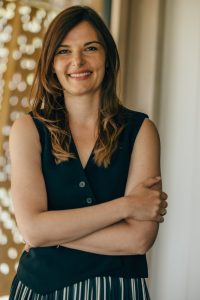Anna Ebmeyer schaut lächelnd mit verschränkten Armen direkt in die Kamera