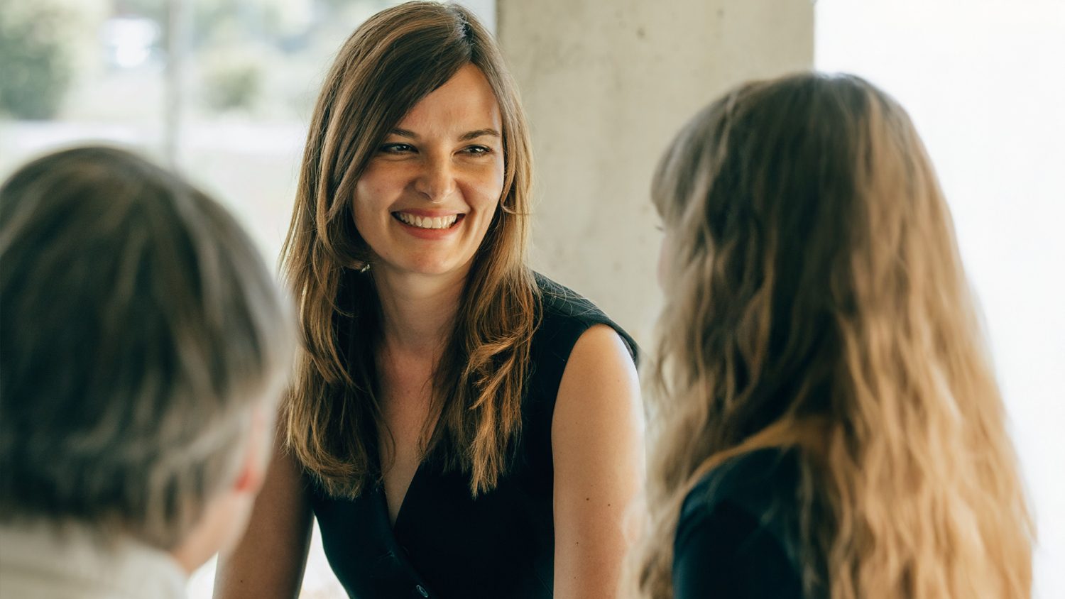 Anna Ebmeyer und ihr Team im lachenden Austausch während eines Gesprächs